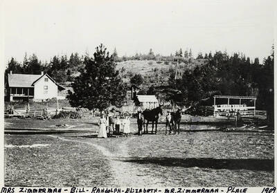 Mrs. Zimmerman with Bill, Randolph, Elizabeth, and Mr. Zimmerman standing in front of the Zimmerman place. Mr. Zimmerman is holding the reins of several horses. Photograph taken in 1909.