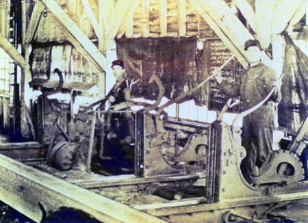 Photograph from slide of men on a carriage sawing logs at the Potlatch Mill.
