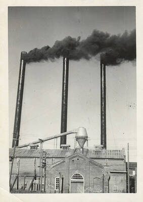 Three smoke stacks bellowing smoke.