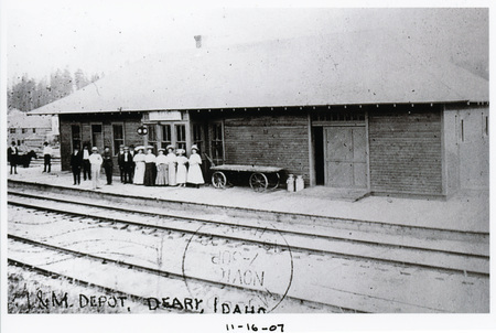 Photograph of the Deary depot with people waiting for a train.