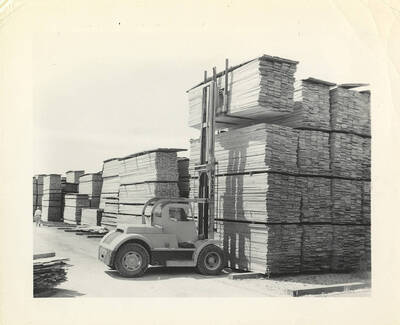 The 'Hyster' lifting lumber from the top of a large stack.
