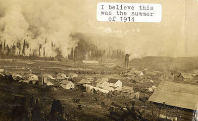 A photograph of Elk River with a fire coming in over the mountains in the summertime.
