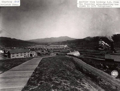 A photograph of another view of Elk River, Idaho looking northeast from the hospital area with the boarding house shown in the left foreground.