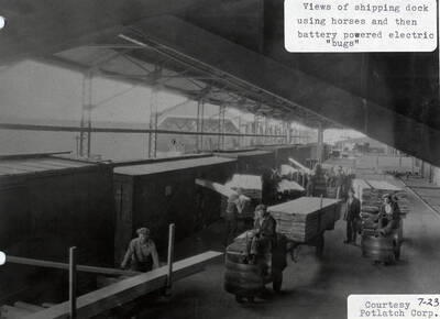 A photograph of the shipping dock using horses and battery powered electric 'bugs.'