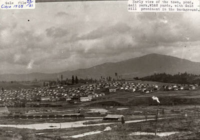 A photograph of Potlatch, Idaho with the view of the town, pond, ball park, WI&M yards, and Gold Hill in the background.