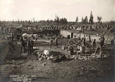 A photograph looking west over workers excavating land for the power plant for the Potlatch Lumber Company.