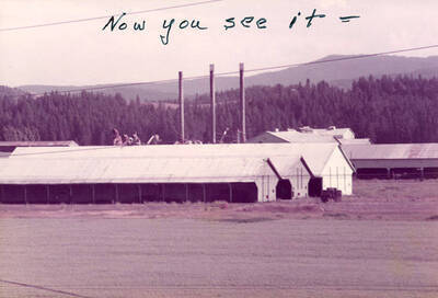 A photograph of three structures with three smokestacks behind them.