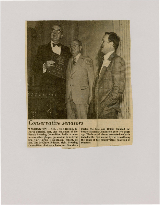 A newspaper article discussing: A picture of 3 senators with the following captions: "WASHINGTON - Sen. Jesse Helms, R-North Carolina, left, vice chairman of the Senate Steering Committee, holds a commemorative plaque presented to retired Sen. Carl Curtis, R-Nebraska, center, as Sen. Jim McClure, R-Idaho, right, Steering Committee chairman looks on. Senators Curtis, McClure and Helms founded the Senate Steering Committee over five years ago. The bronzed plaque presented to Curtis included the first memo by Curtis outlining the goals of the conservative coalition of senators."