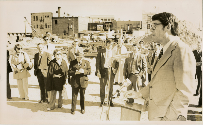 Photo description: Governor Evans is giving a speech in front of crowd with Ben J Plastino front and center. Text back translation "Governor John V. Evans in Idaho Falls Idaho Falls Post Register Executive Editor Ben J. Plastino, center, front row"