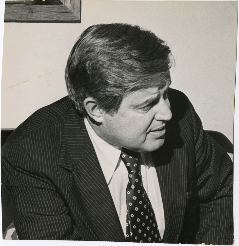 Photo Description: Senator Frank Church is talking with someone to the right off camera. Text back translation "Page A-5 1x3 US Frank Church Idaho Senator Frank Church" Notes read on back crossed off "ngton, D.C. John Denver, the"