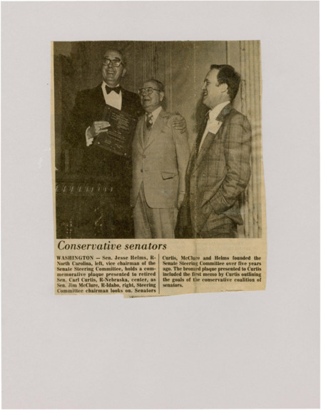 A newspaper article discussing: A picture of 3 senators with the following captions: "WASHINGTON - Sen. Jesse Helms, R-North Carolina, left, vice chairman of the Senate Steering Committee, holds a commemorative plaque presented to retired Sen. Carl Curtis, R-Nebraska, center, as Sen. Jim McClure, R-Idaho, right, Steering Committee chairman looks on. Senators Curtis, McClure and Helms founded the Senate Steering Committee over five years ago. The bronzed plaque presented to Curtis included the first memo by Curtis outlining the goals of the conservative coalition of senators."