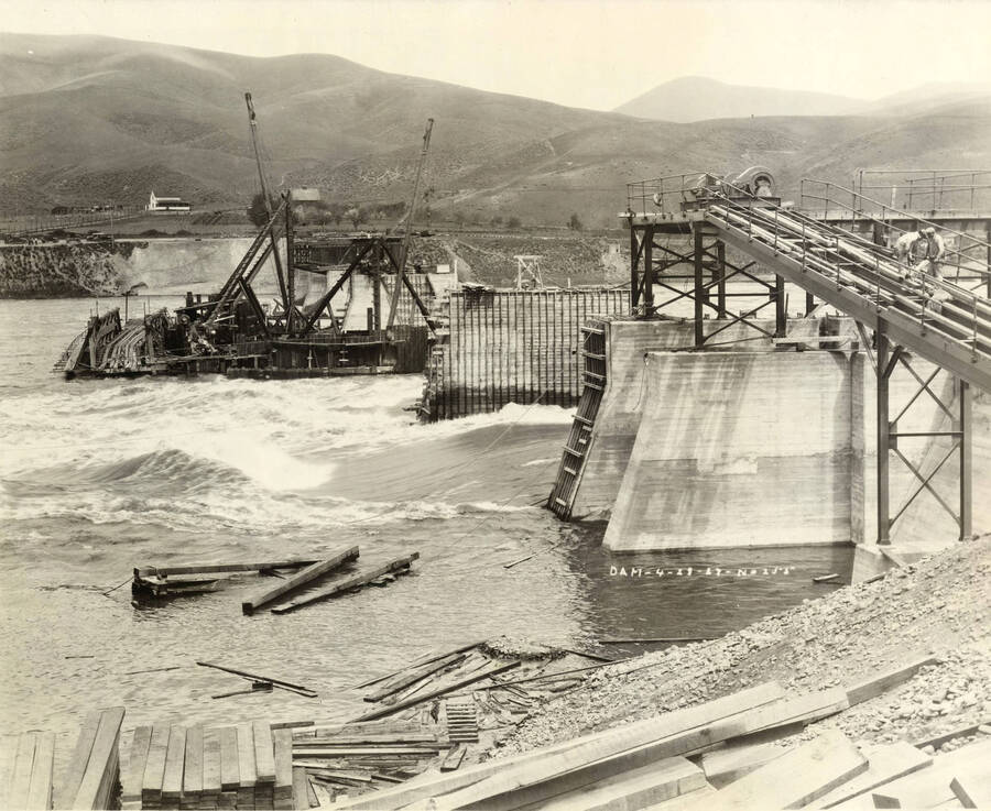 The Clearwater river rushes through a partially completed Lewiston Dam. Written on the photograph is 'Dam, Lewiston. 4/28/1927 No. 255.'