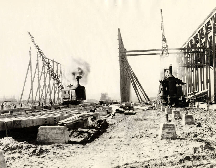 Two locomotive cranes work to help construct the rough-dry shed at the Lewiston Mill. Written on the photograph is '3/11/1927 No. 215.'