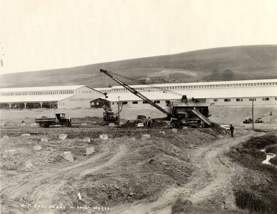 A crane lifts a concrete from the back of a dump truck. Written on the photograph is 'CT CO's Plant - 4/30/1927 No. 263.'