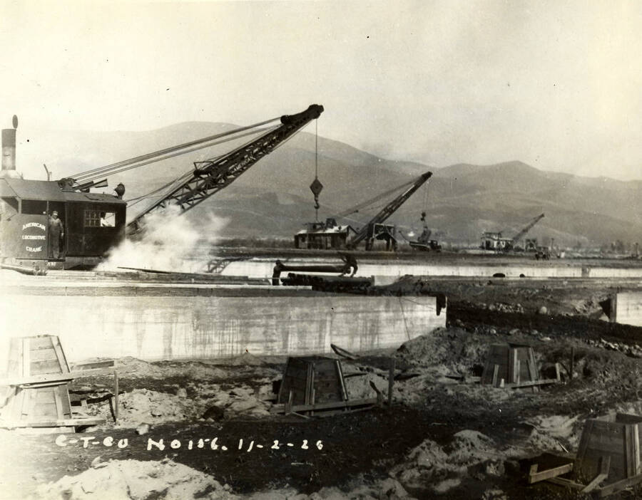 Three cranes work on cement foundations of the Lewiston Mill. Written on the photograph is 'CT CO Plant 11/2/1926 No. 156.'