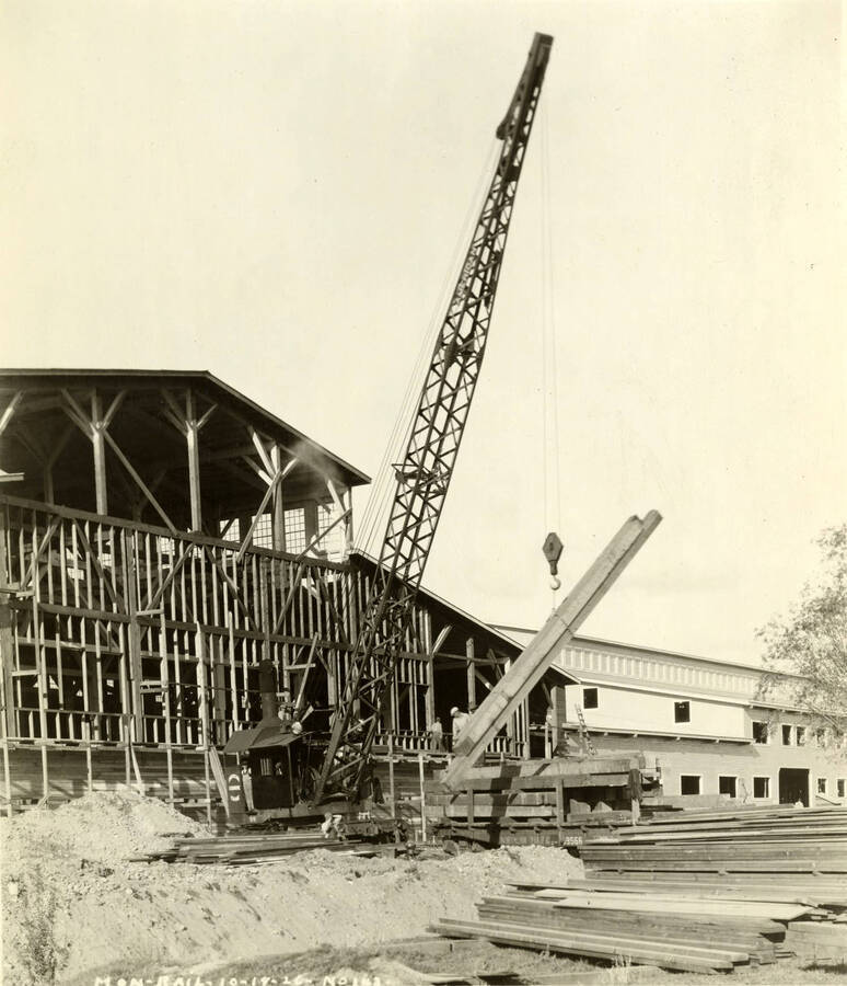 A crane lifts lumber beams at the construction of the monorail. Written on the photograph is 'Mon-Rail 10/18/1926 No. 143'