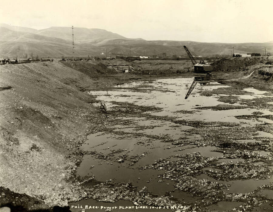 a crane works on the tailrace near the power plant. Written on the photograph is 'Tail Race power plant site 10/19/1926, No. 142'