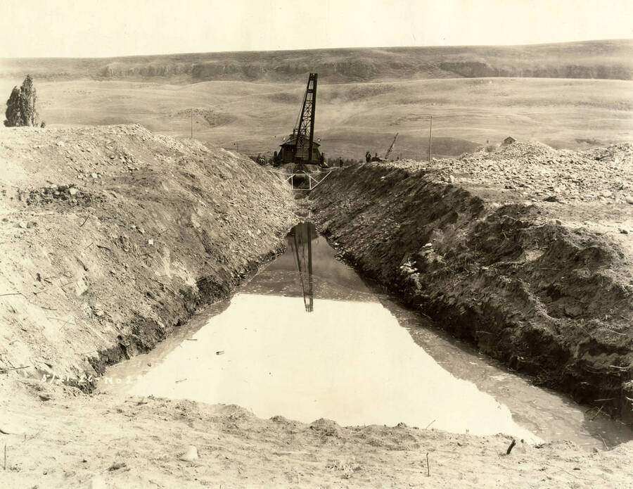 Looking down a water channel towards a crane. Written on the photograph is '5/21/1926 No. 23'