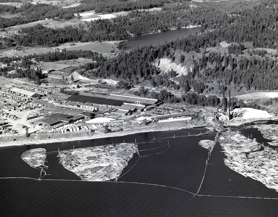 An aerial photograph of the Rutledge Mill in Coeur d'Alene, Idaho. Shown are the mill itself as well the log pond. On the back of the photograph is 'Western Ways, Inc. Aerial Photographic Specialists  275 Vera Drive Corvallis Oregon, Phone 35266