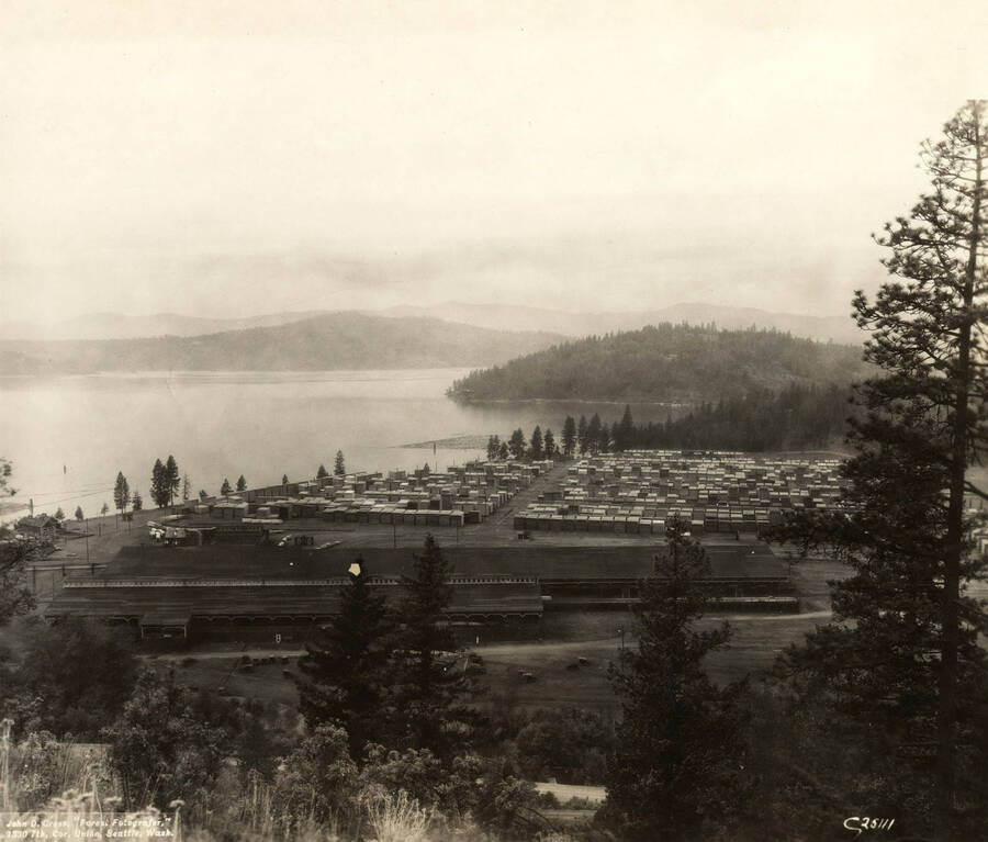 View from the hill behind the mill showing the location of the remanufacturing building, planer building, and grading shed. Also in view are Tubbs Hill and Lake Coeur d'Alene. Written on the back is 'Same view as #2775 from further up the hill (light poor).'