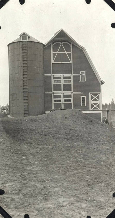 A barn with a silo next to it are shown.