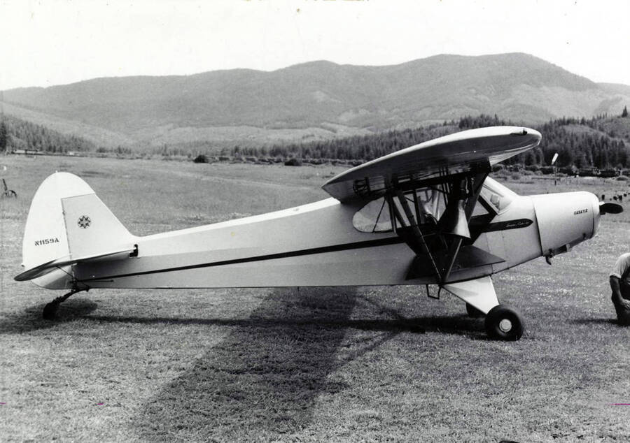 A plane used for patrolling and spotting forest fires. Tail fin number is N1159A. Description on the back of the photograph reads "Aerial patrol plane. Note loudspeakers under wing. AB Curtis photo file."