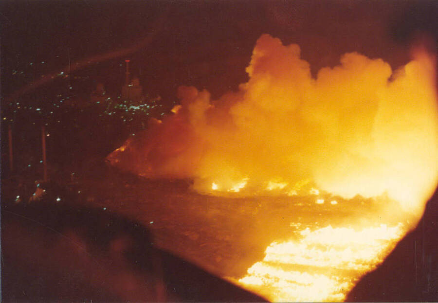 Flames and smoke are captured while buildings in the seen in the background
