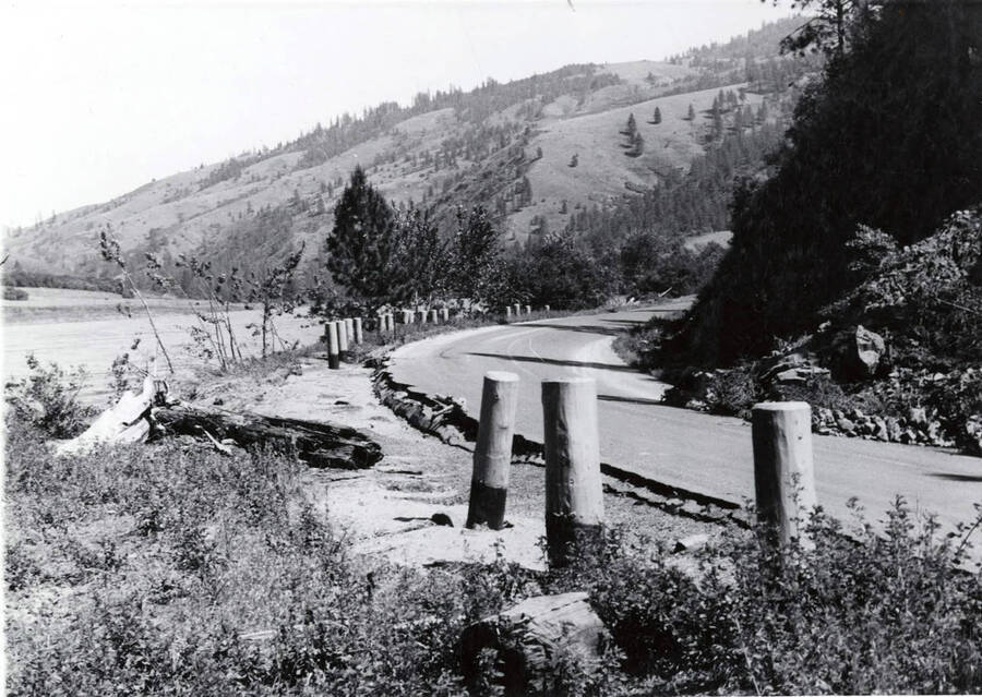 The road that was damaged in the floodwaters. A river can bee seen on the left of the photograph.