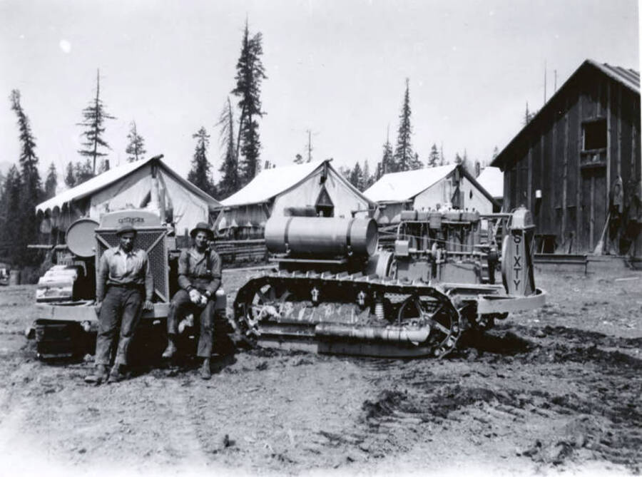 Two men sit on the front of one bulldozer while another is shown from the side. Description on the back of the photography reads "1929 Cp. B"