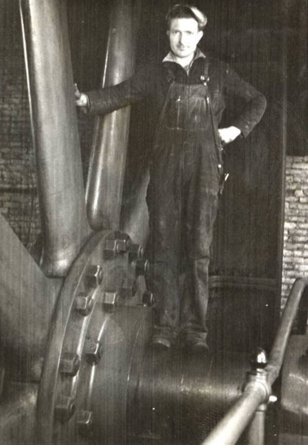 Lee Gale on Corliss engine shaft.  Note size of spokes and bolts in flywheel compared to a six foot man.  He stands on a shaft 22' in diameter.