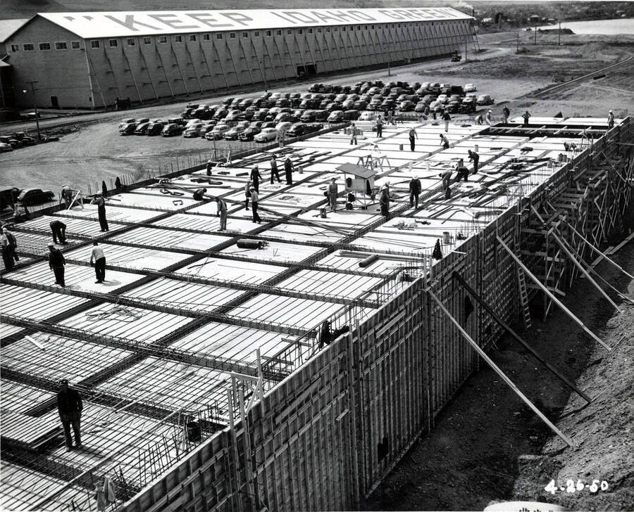 Men work on the roof of the Clearwater paper mill plant laying rebar