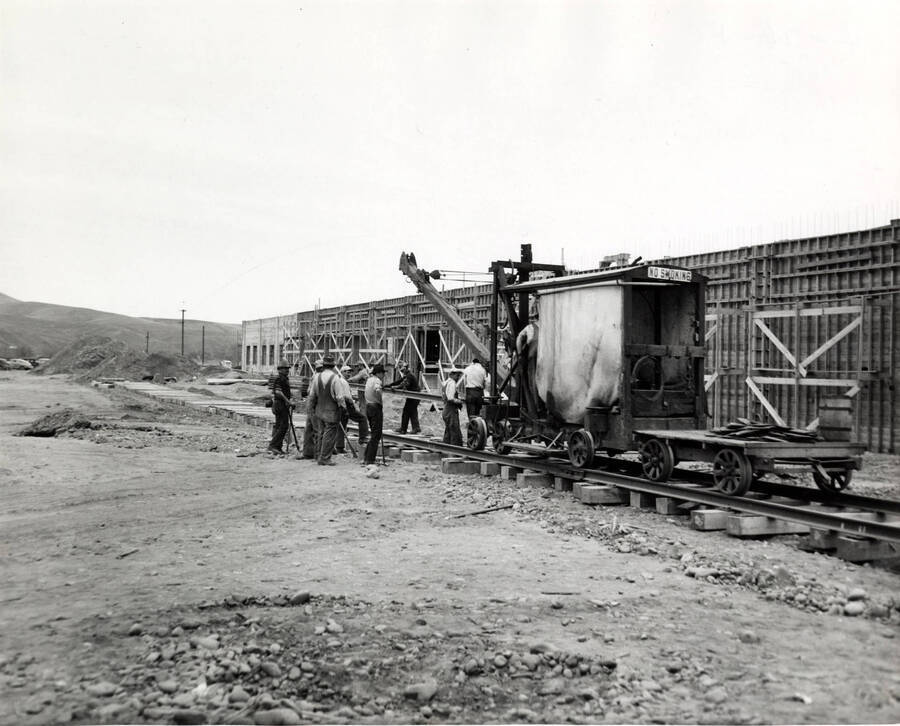 Men work to lay railroad track near a partially constructed building at the Clearwater paper mill plant