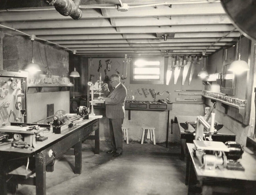 Man in a home workshop containing various types of carpentry tools.