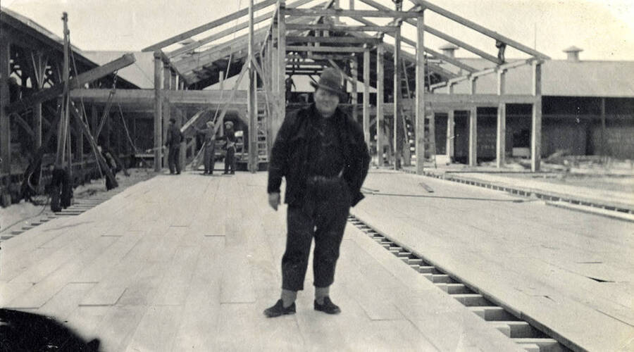 Unidentified man standing in front of dry shed #6 which is under construction.