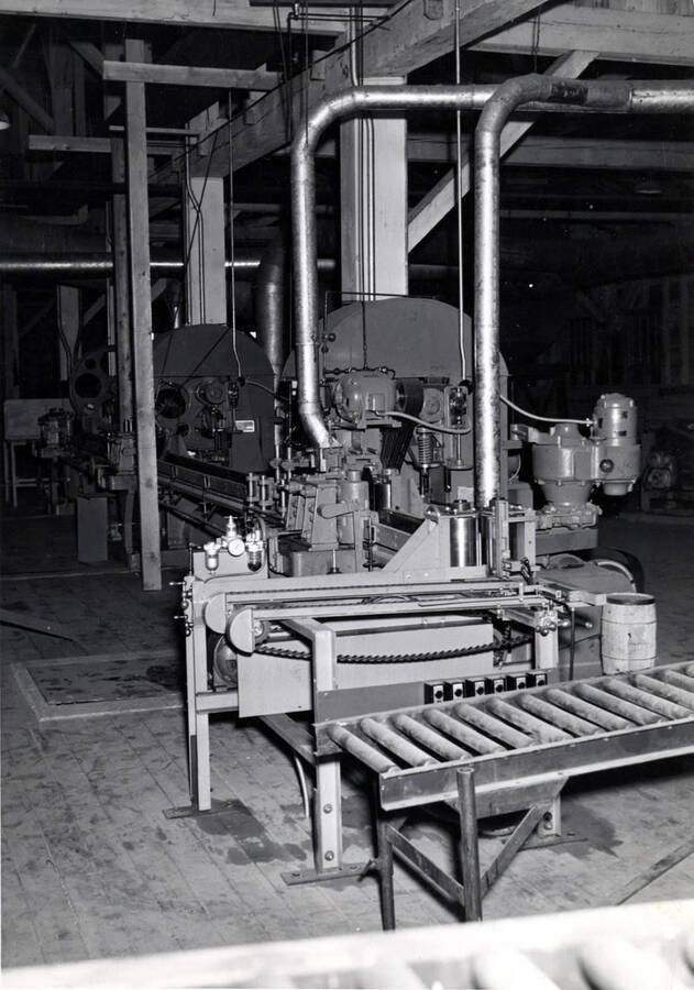 A piece of mill machinery next to a roller conveyor belt.