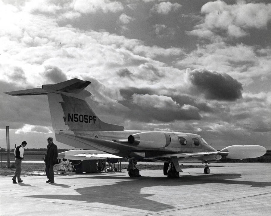 One of Potlatch's Learjet jets before it was painted at the Learjet factory in Wichita, Kansas. Two men are near the tail end of the plane. The tail number for this plan reads of N505PF.