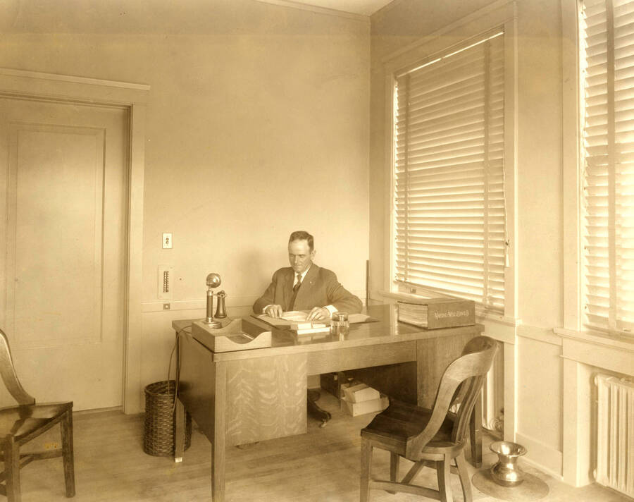 H.L.M. Gleave, Townsite Supervisor at his desk.
