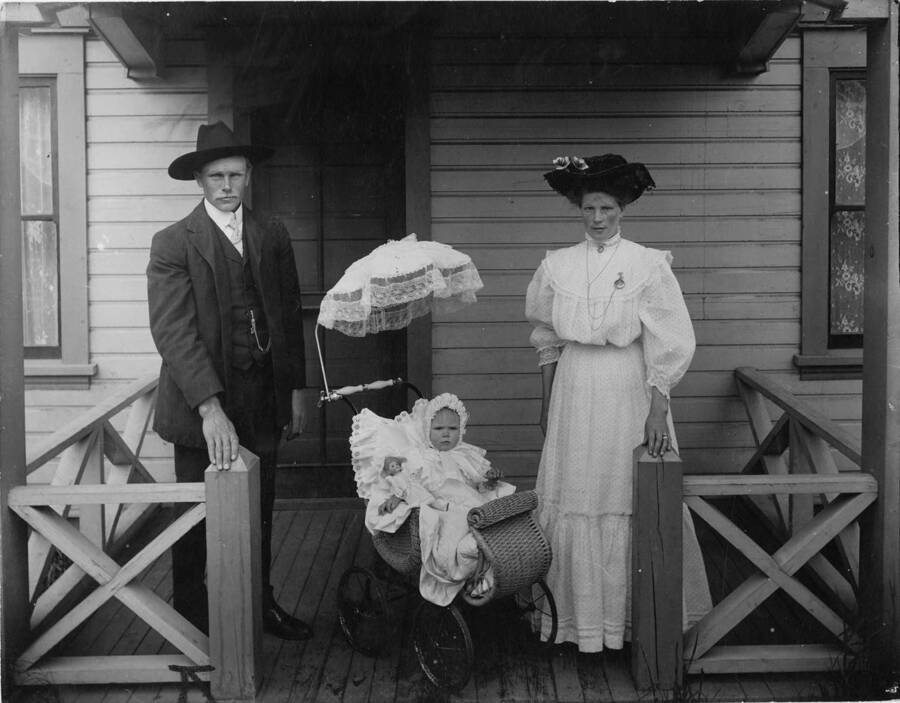 Fred Fredrickson poses with his wife and child on a porch of a house in Potlatch, Idaho.