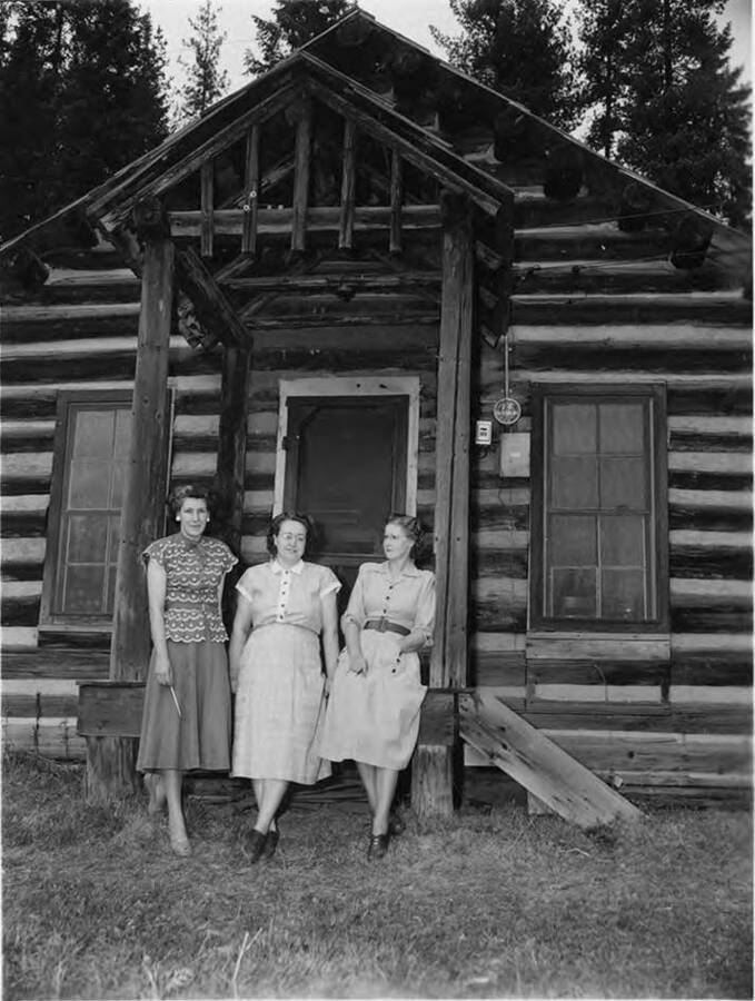 The teachers of the school in Headquarters, Idaho stand in front of the school. They are 'Joy Boll, Helen Nyberg, and Gladys Clarke.'