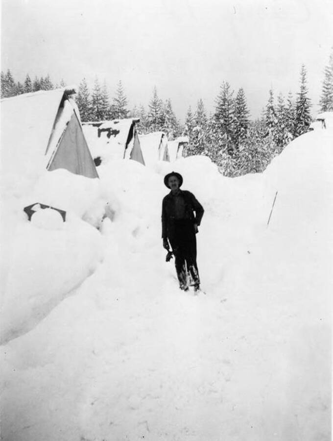 A man stands in between bunkhouses covered in snow at camp 12, near Deary, Idaho.