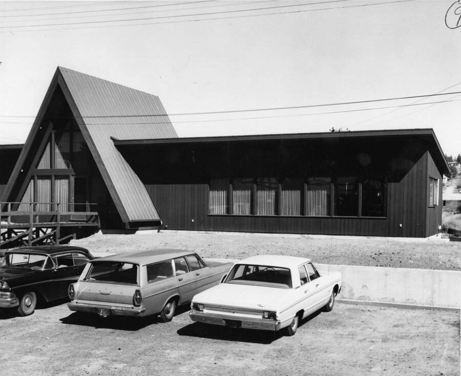 The exterior of the Potlatch Unit Office. Parked in front of it are three cars.