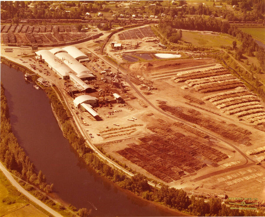 The plywood plant at St. Maries, Idaho. In the picture is the St. Joe River (left side of the photograph) and the decks of logs waiting to be processed (right side of the photograph).