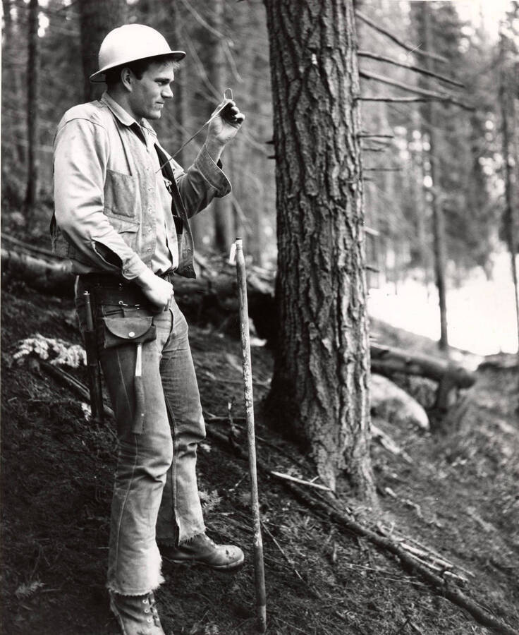 Forester Norman Tomilson uses a prism to check light on Camal Creek, north of Pierce, Idaho.