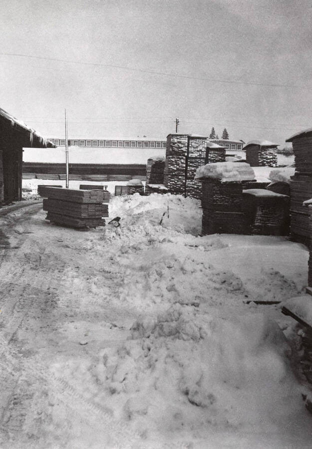 View of snow covered lumber yard.