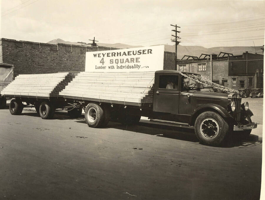 A truck loaded with lumber boards is parked in Lewiston. The sign on top reads 'Weyerhaeuser 4 square Lumber with individuality.'