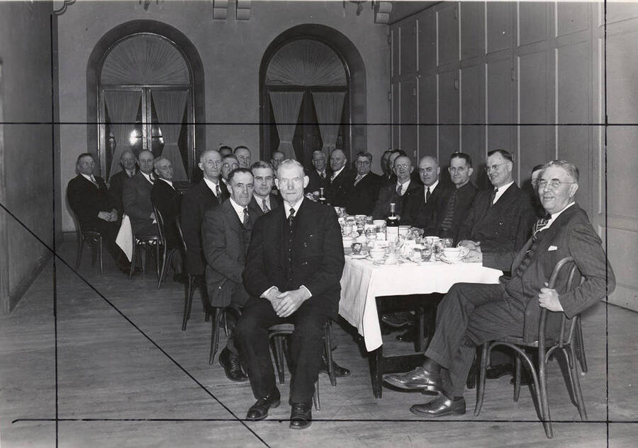 Men sit around an L shaped table at the Lewis Clark Hotel. The men are unidentified.