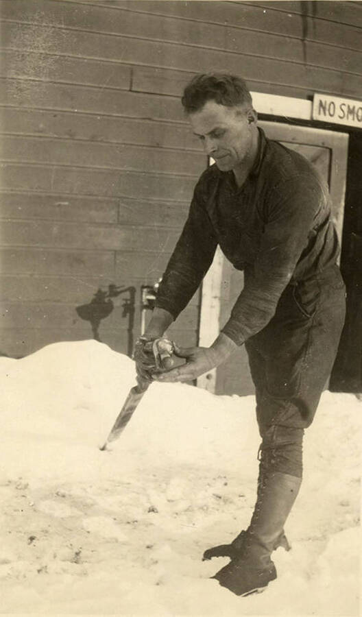 John Johnson demonstrates the use of a tool. According to the description, Mr. Johnson is a blacksmith at the Rutledge Mill.