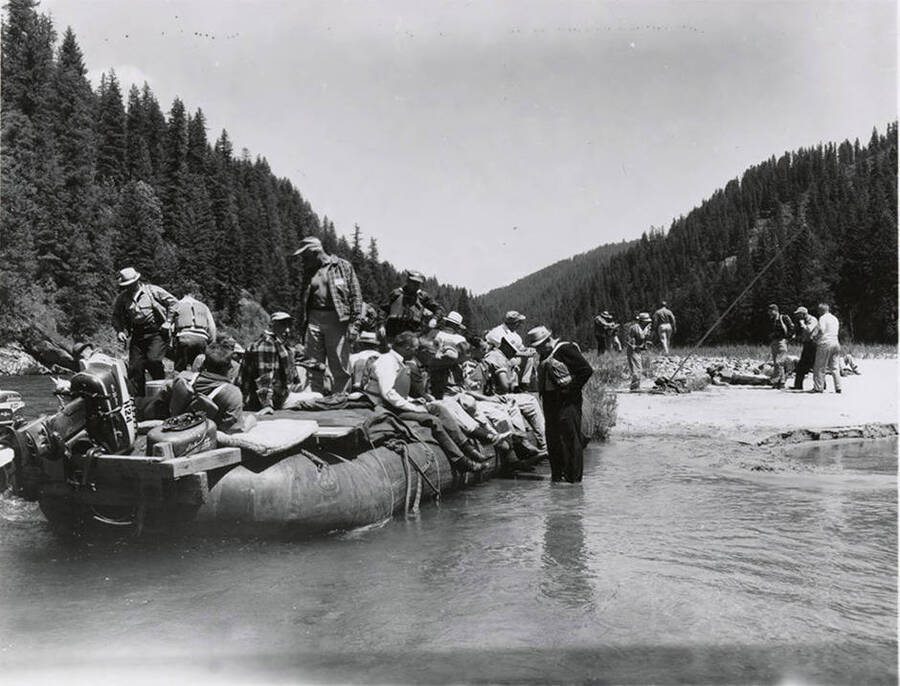 Members of the land board are sitting on a raft during a fishing trip.