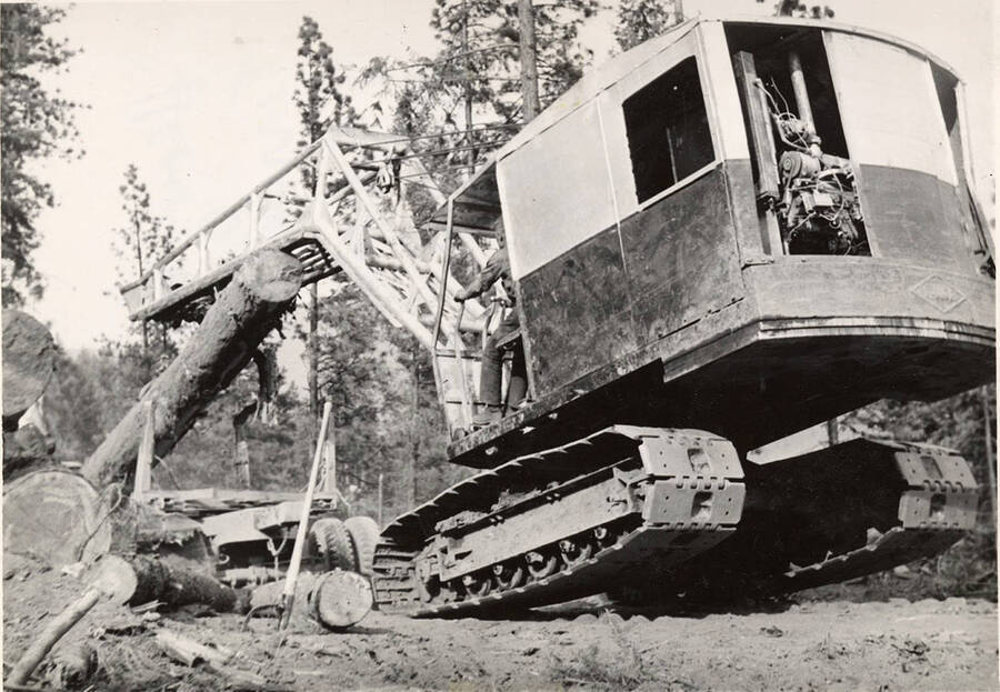 A crane tips forward trying to pick up a log. The description on the back of the photograph reads ' Heavy log in Harris Ferris timber spring of '51. Shovel operated by Arron Reed.'