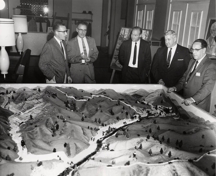 Men stand behind a model of Potlatch logging area.